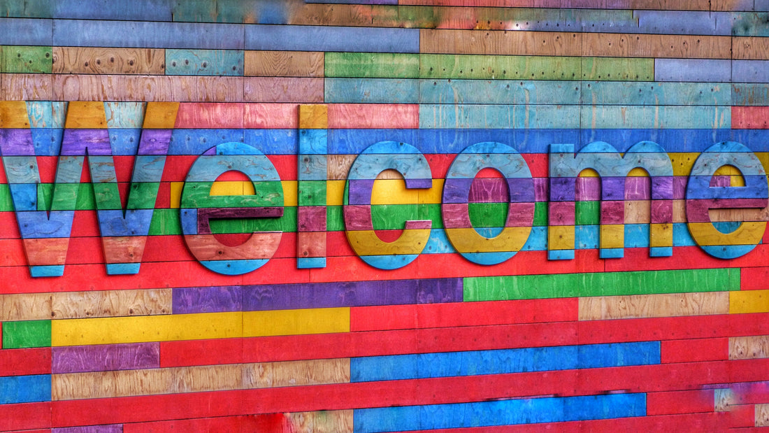 A welcome sign made of wood with different colors.